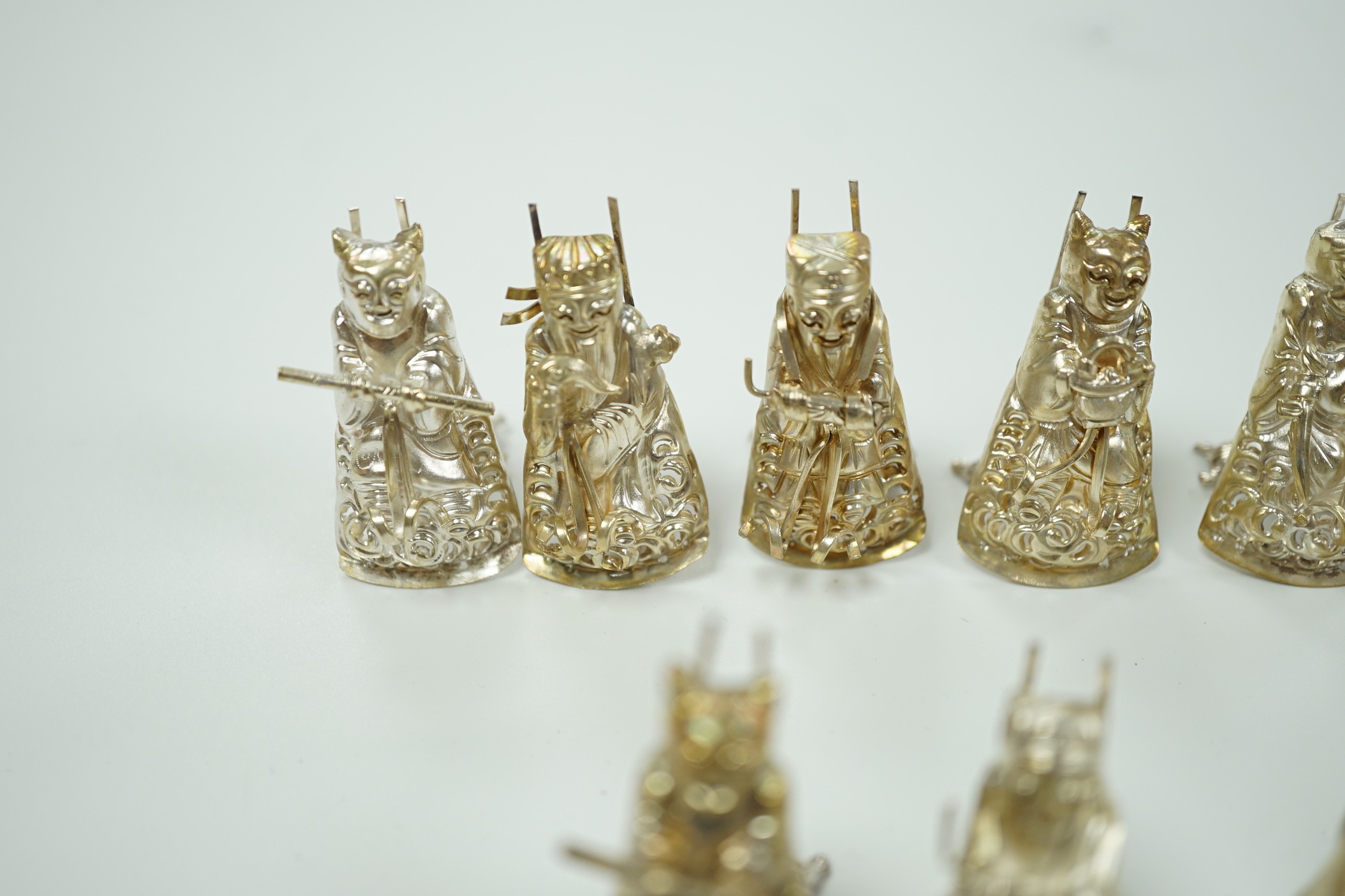 A set of eleven Chinese white metal menu card supports, in the form of artisans, 41mm.